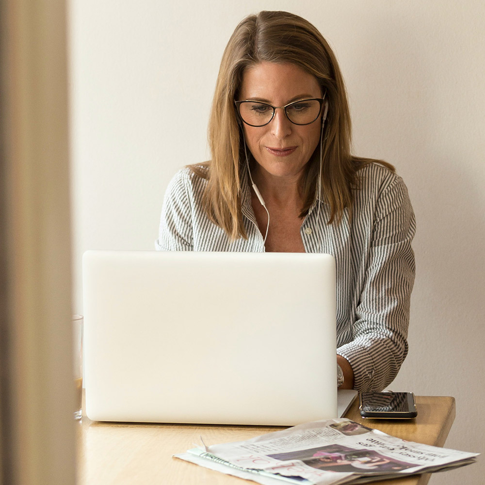 woman wearing glasses in front of a computer